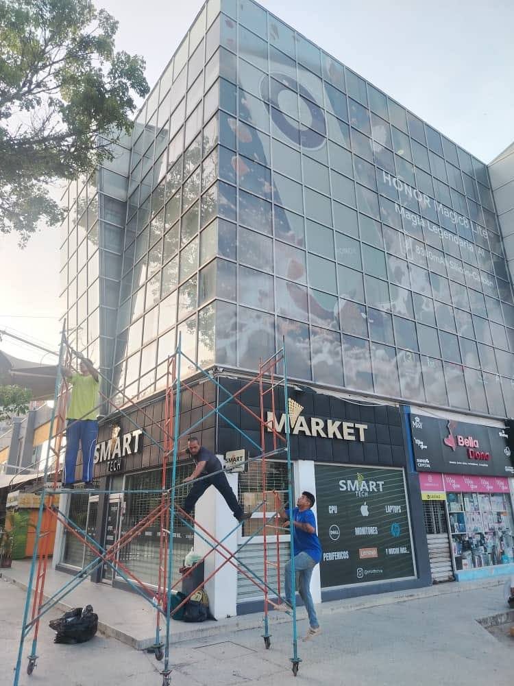 Fachada comercial con vinil en muro cortina y letreros de Smart Tech