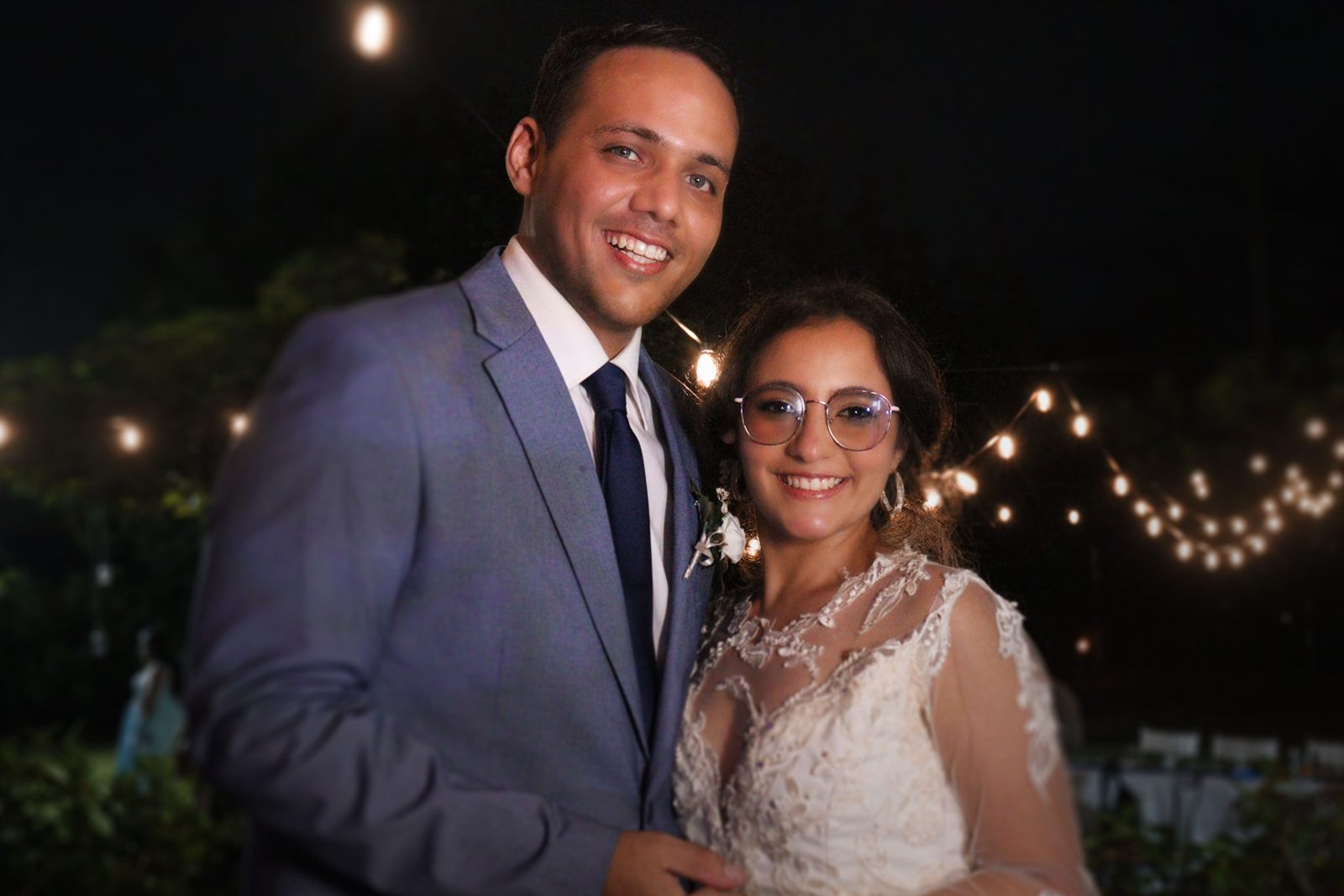 Novios sonriendo en una celebración nocturna