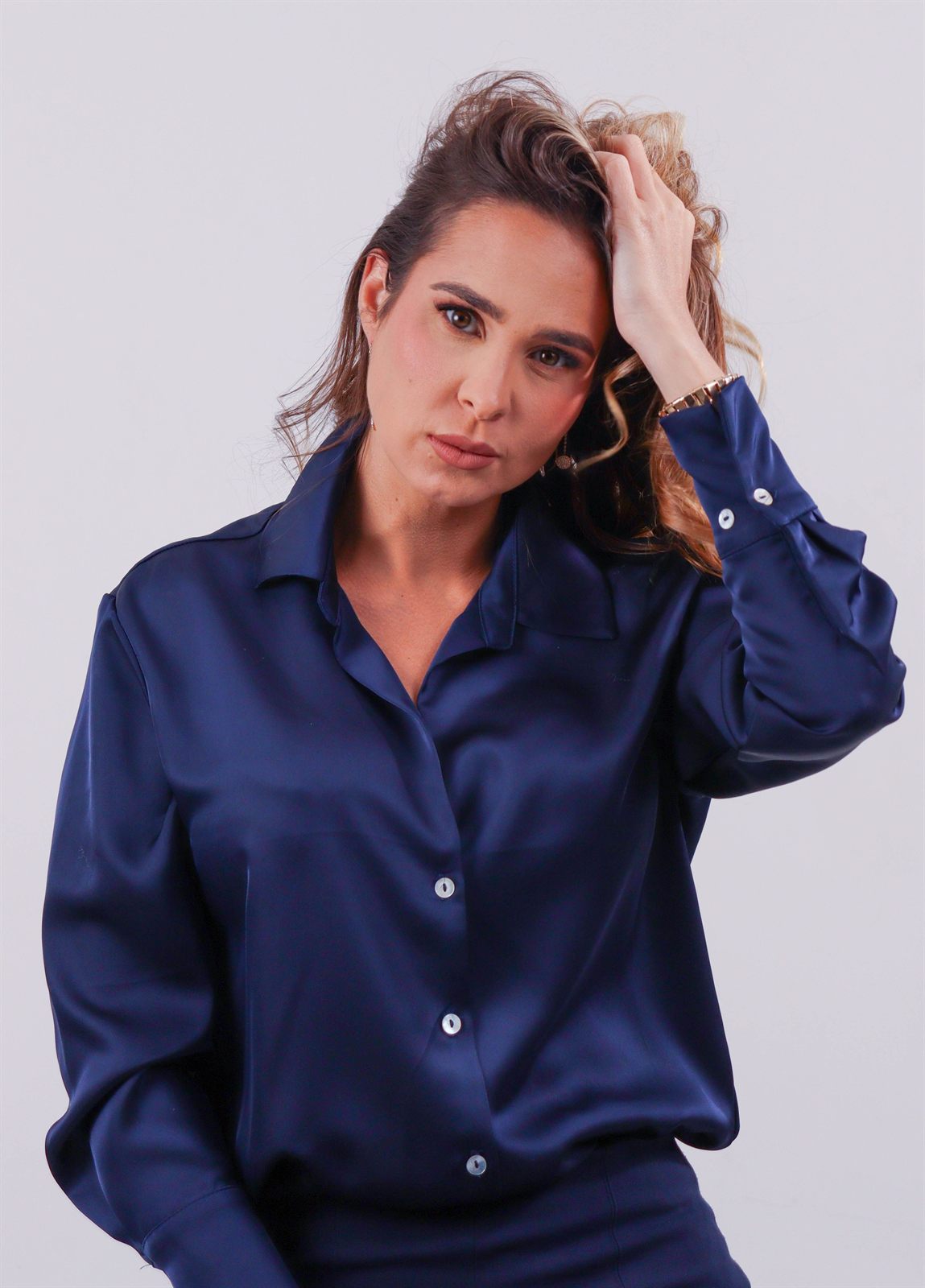 Retrato editorial de una mujer con camisa de satén azul